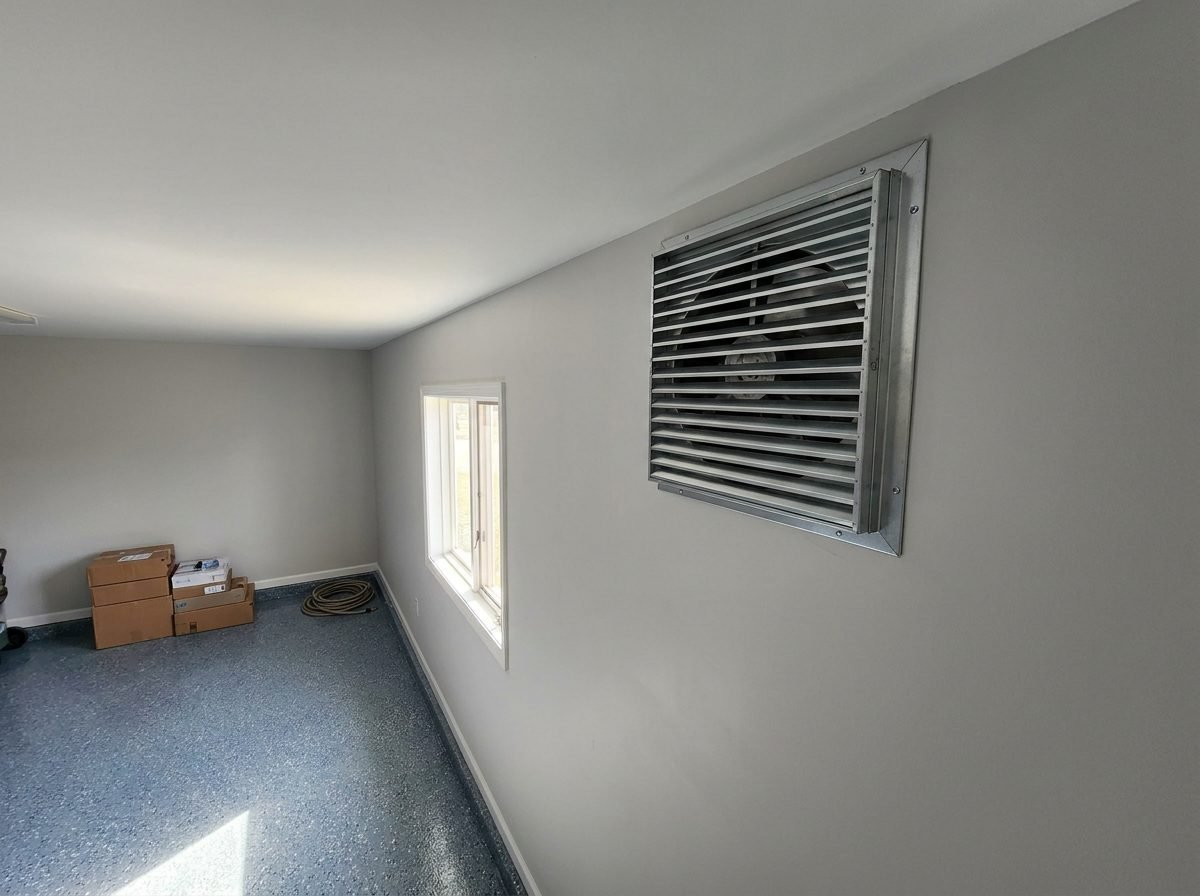 Wall-mounted garage exhaust vent fan installed near the ceiling